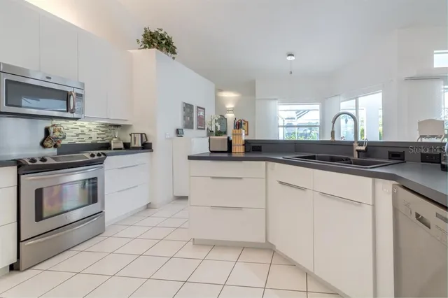 a kitchen with white cabinets and appliances