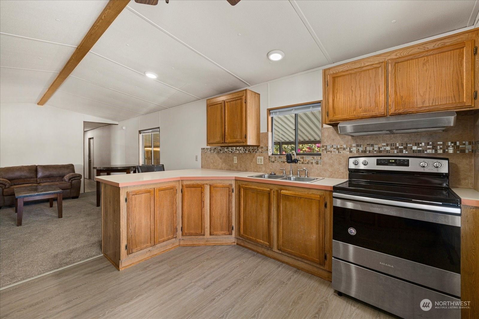 2302 R Street Southeast, Unit 46 Auburn, WA 98002 - Photo 11 of 25 a kitchen with granite countertop a stove a sink and a refrigerator