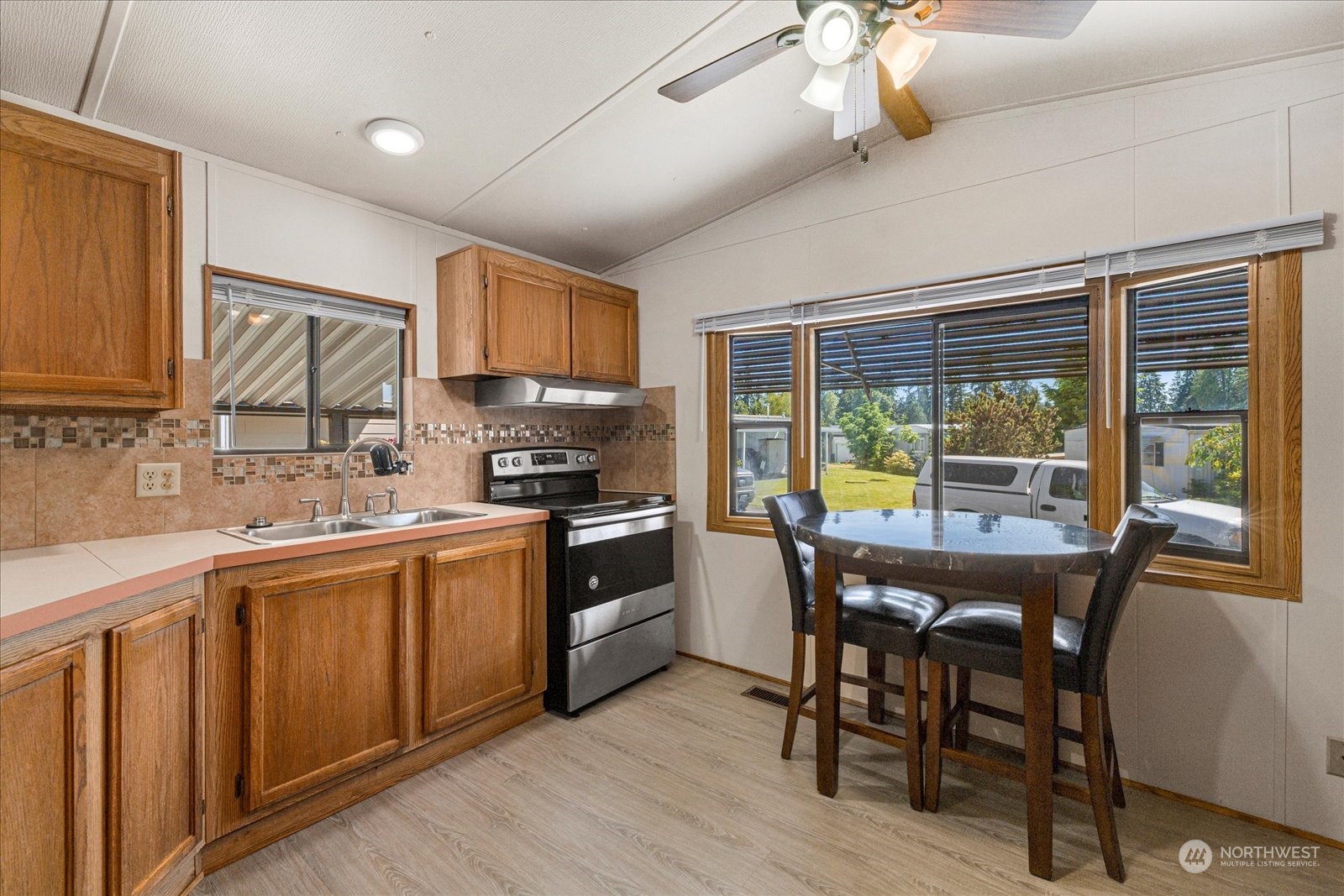 2302 R Street Southeast, Unit 46 Auburn, WA 98002 - Photo 10 of 25 a kitchen with stainless steel appliances granite countertop a stove a sink dishwasher a microwave oven with cabinets and wooden floor