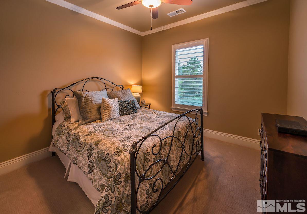 12745 Silver Wolf Road Reno, NV 89511 - Photo 18 of 21 a bedroom with a bed and a chandelier