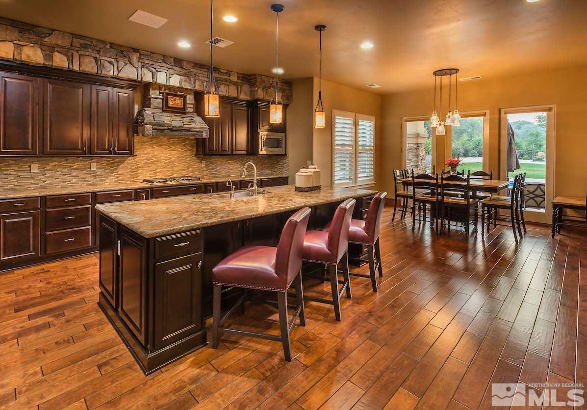 12745 Silver Wolf Road Reno, NV 89511 - Photo 4 of 21 a kitchen with stainless steel appliances granite countertop a table chairs stove and a wooden floors