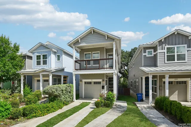 a front view of a house with a yard and potted plants