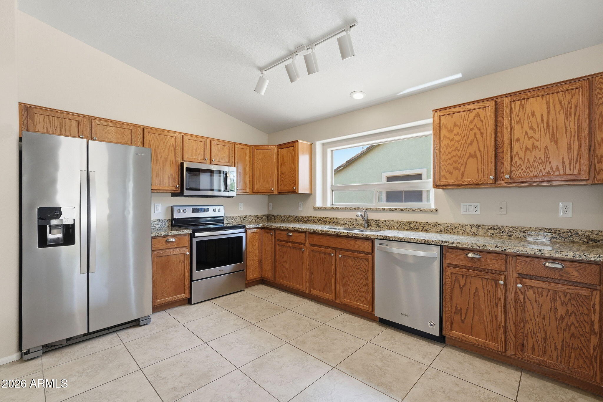 2022 South 160th Lane Goodyear, AZ 85338 - Photo 11 of 36 a kitchen with stainless steel appliances granite countertop a refrigerator sink and cabinets