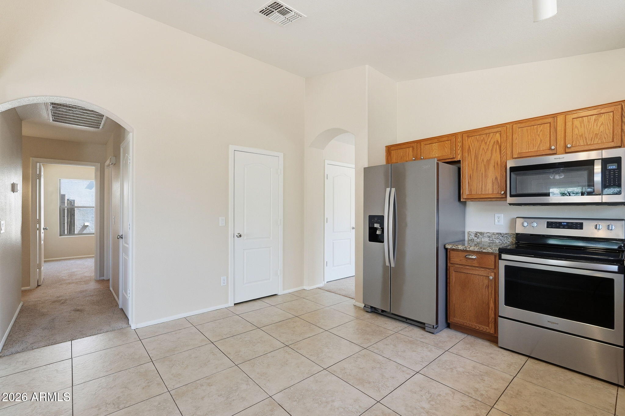 2022 South 160th Lane Goodyear, AZ 85338 - Photo 14 of 36 a kitchen with stainless steel appliances granite countertop a refrigerator and a stove top oven