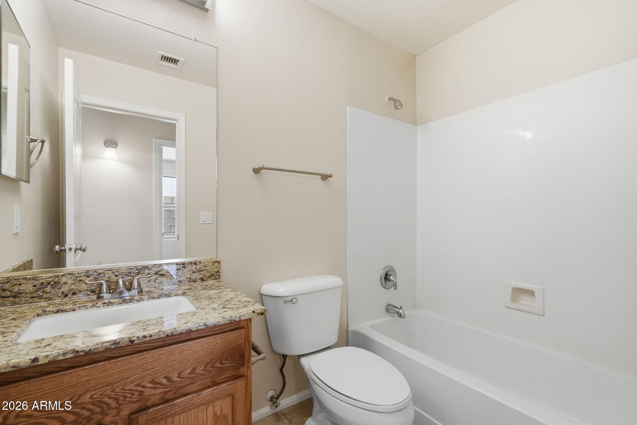 2022 South 160th Lane Goodyear, AZ 85338 - Photo 27 of 36 a bathroom with a granite countertop toilet a sink and a bathtub