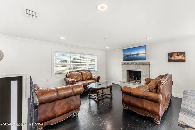 a living room with furniture a fireplace and a large window
