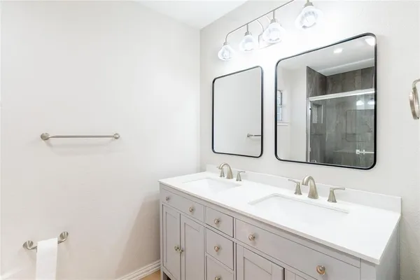 a bathroom with a double vanity sink and mirror
