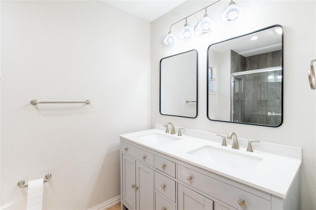 313 South Prairie Street Pilot Point, TX 76258 - Photo 11 of 16 a bathroom with a double vanity sink and mirror