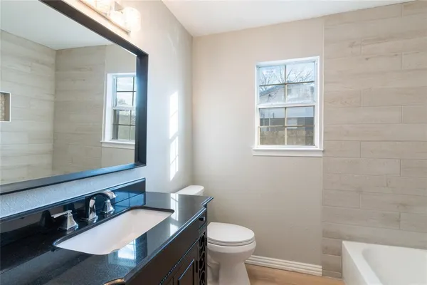 a bathroom with a sink a toilet a mirror and shower