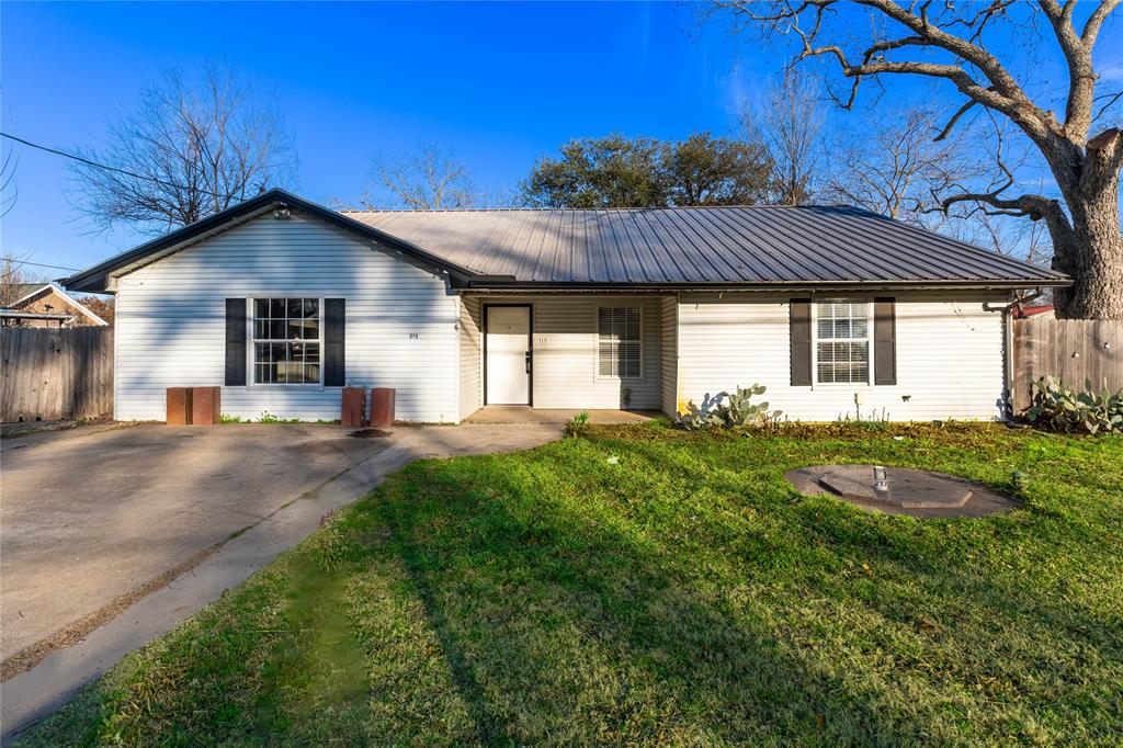 313 South Prairie Street Pilot Point, TX 76258 - Photo 2 of 16 a front view of a house with garden