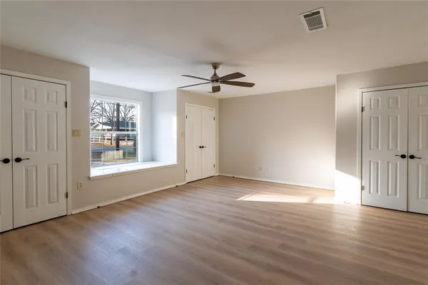 a view of a livingroom with wooden floor and a ceiling fan