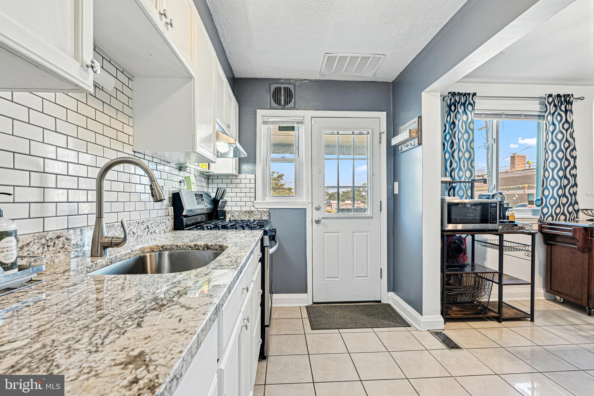 a kitchen with granite countertop a sink and a refrigerator