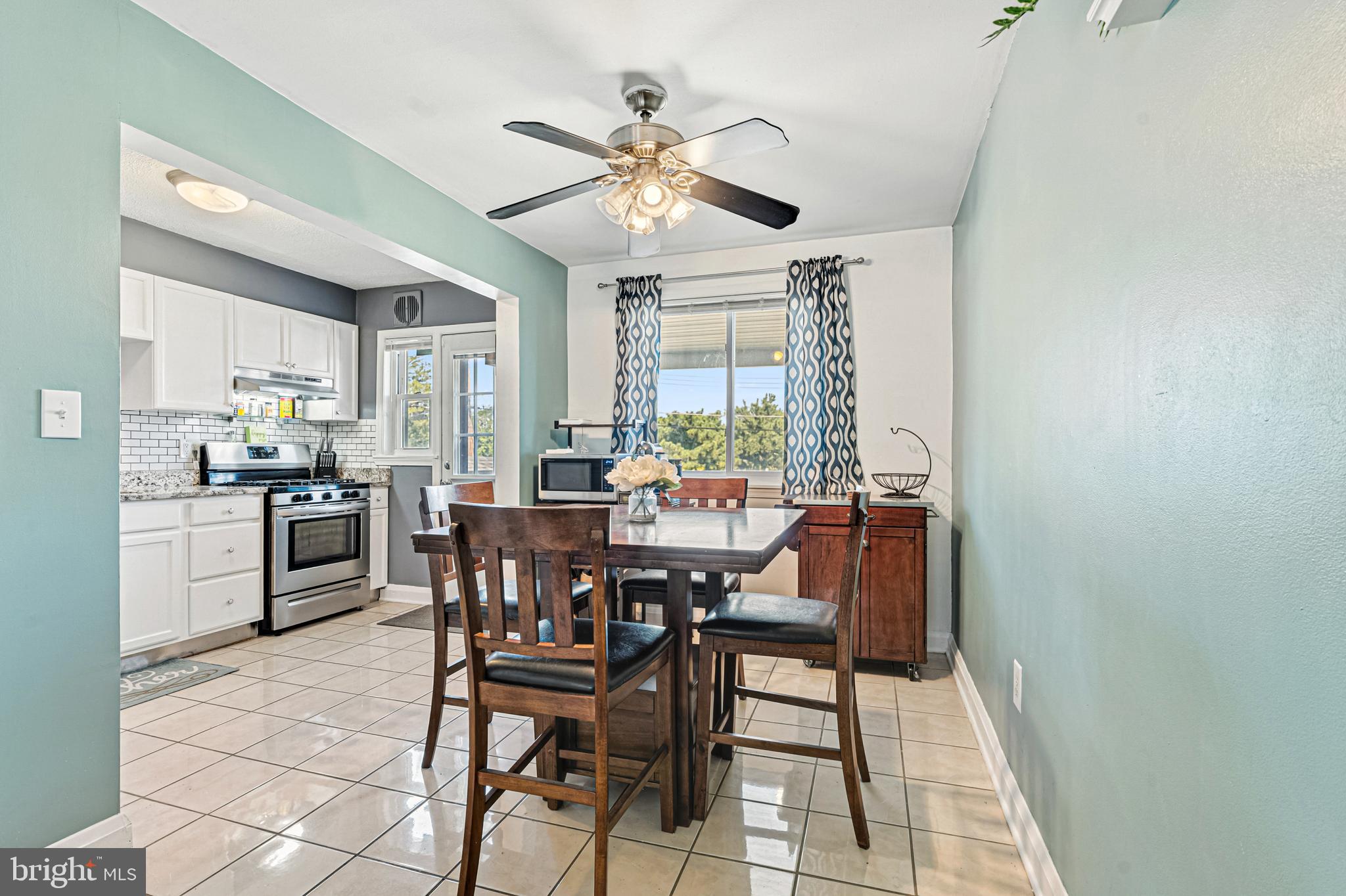 8272 Kavanagh Road Baltimore, MD 21222 - Photo 7 of 32 a kitchen with a dining table chairs and white cabinets