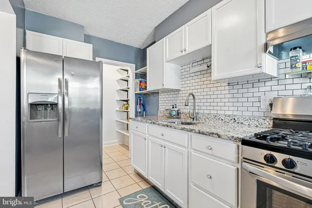 a kitchen with stainless steel appliances granite countertop a refrigerator and a sink