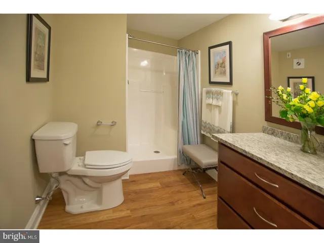 a bathroom with a granite countertop sink toilet and shower