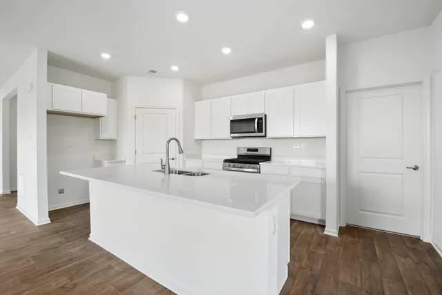 a kitchen with sink a microwave and refrigerator