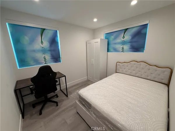a bedroom with a bed and a painting on the wall
