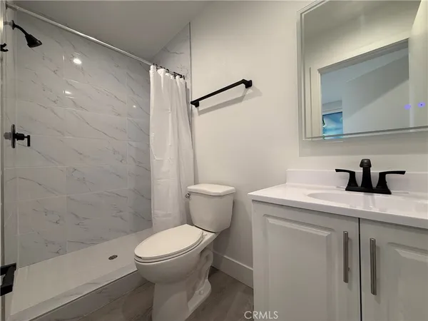 a bathroom with a granite countertop toilet sink and shower