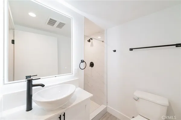 a bathroom with a sink a toilet and shower