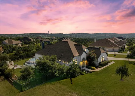 an aerial view of a house with a garden and lake view