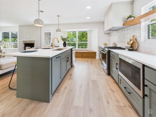a kitchen with stainless steel appliances granite countertop wooden floors and sink