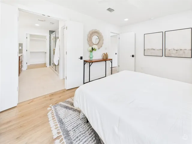 a spacious bedroom with a bed and a chandelier