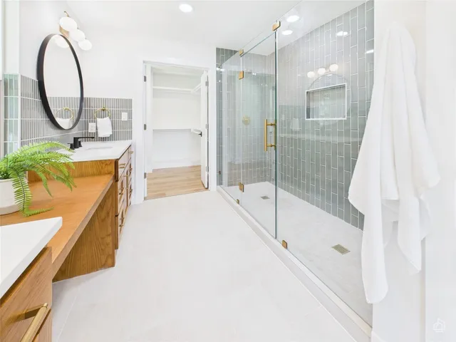 a bathroom with a tub sink mirror and a shower