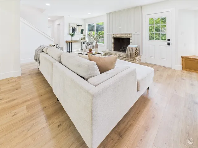 a living room with fireplace furniture and a wooden floor