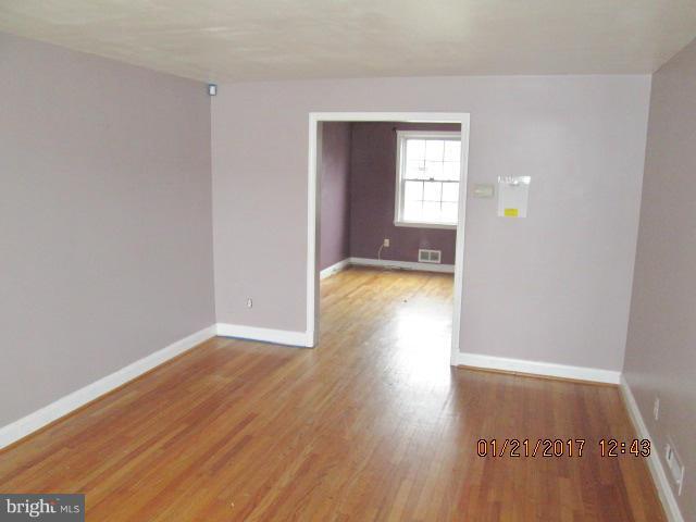 4416 Eldone Road Baltimore, MD 21229 - Photo 3 of 21 a view of an empty room with wooden floor and a window