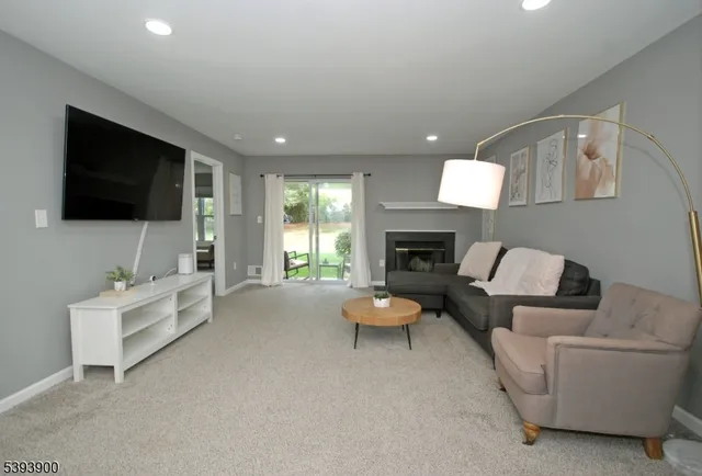 a living room with furniture a fireplace and a flat screen tv