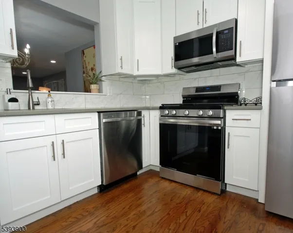 a kitchen with stainless steel appliances granite countertop a stove microwave and sink