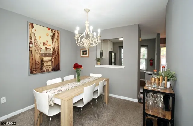 a view of a dining room with furniture a chandelier and wooden floor