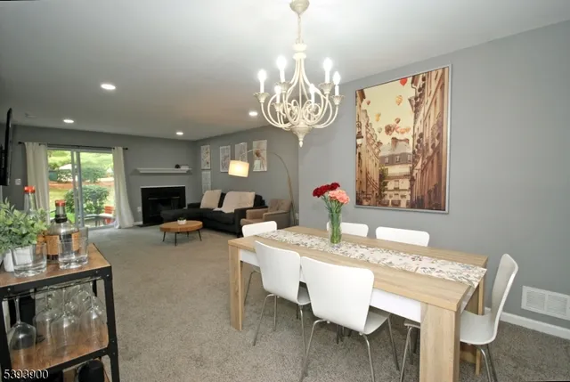a dining room with wooden floor a chandelier a wooden table and chairs