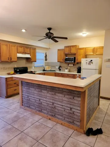 a kitchen with kitchen island a sink stainless steel appliances and cabinets