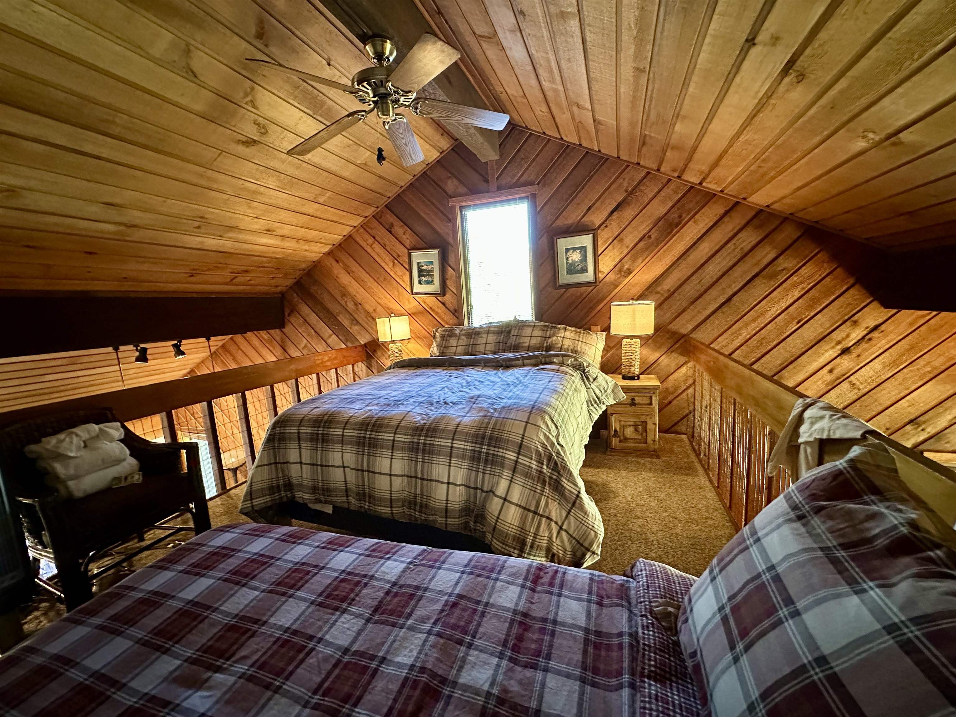 315 Fascination, Unit 315 Mammoth Lakes, CA 93546 - Photo 33 of 44 Loft bedroom featuring sloped wood-paneled walls and ceiling, a ceiling fan with integrated lighting, a single window, and carpeted flooring