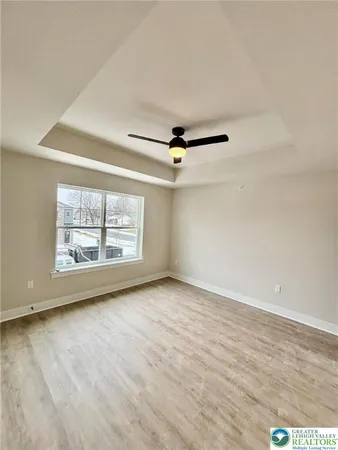 an empty room with windows and fan
