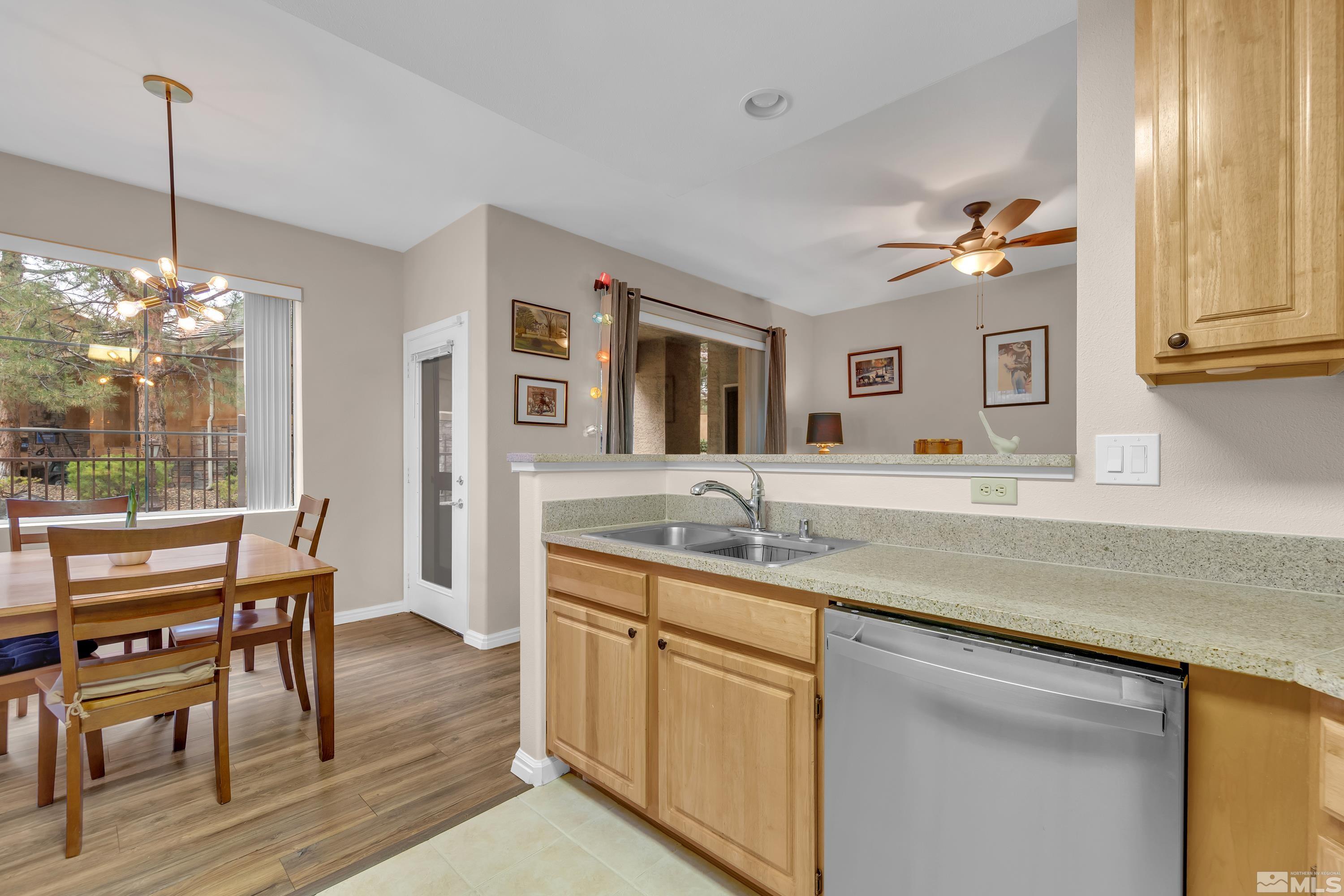 900 South Meadows Parkway, Unit 111 Reno, NV 89521 - Photo 11 of 35 a kitchen with kitchen island granite countertop a sink cabinets and wooden floor