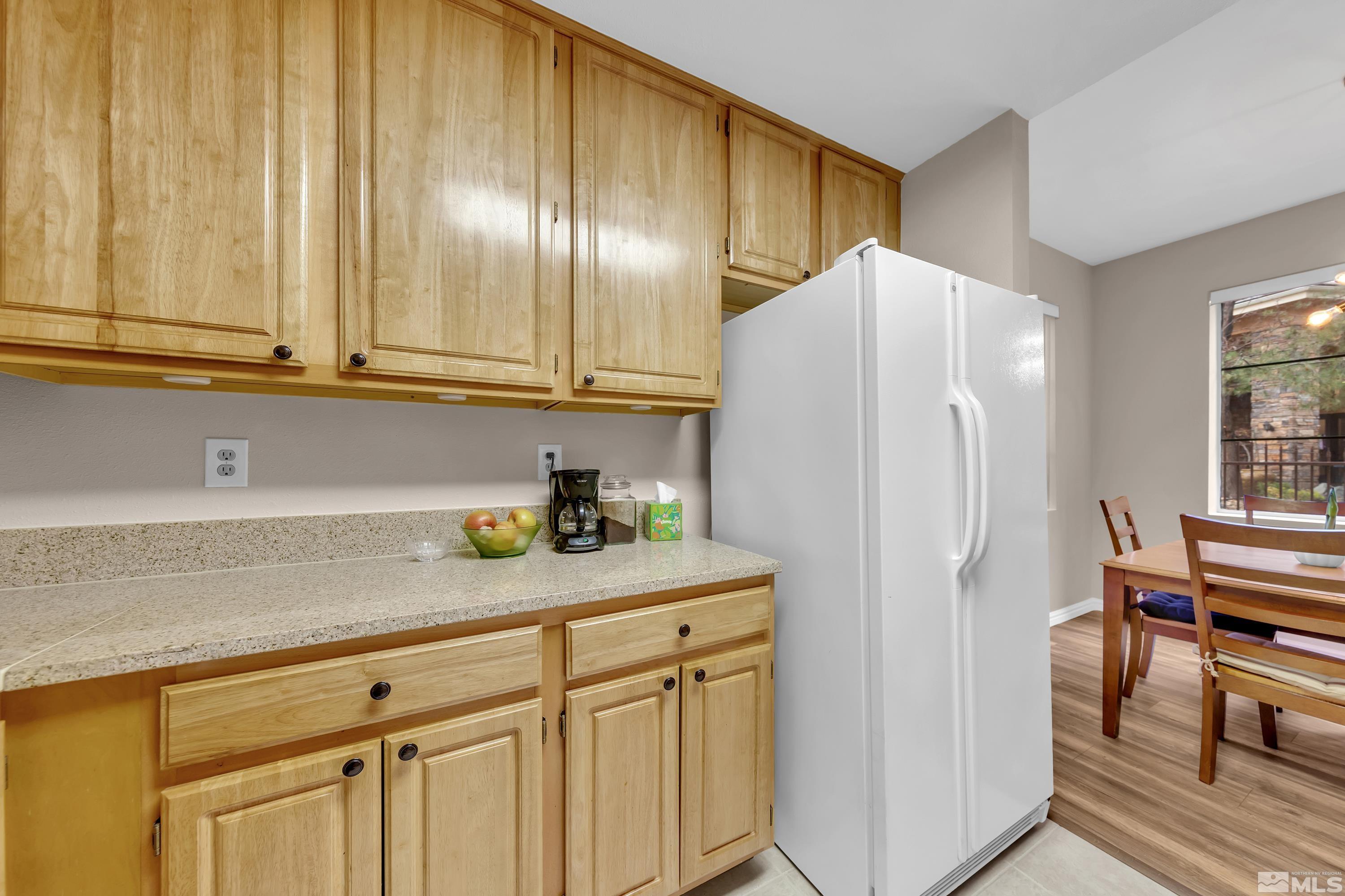 900 South Meadows Parkway, Unit 111 Reno, NV 89521 - Photo 12 of 35 a kitchen with stainless steel appliances white cabinets and a refrigerator
