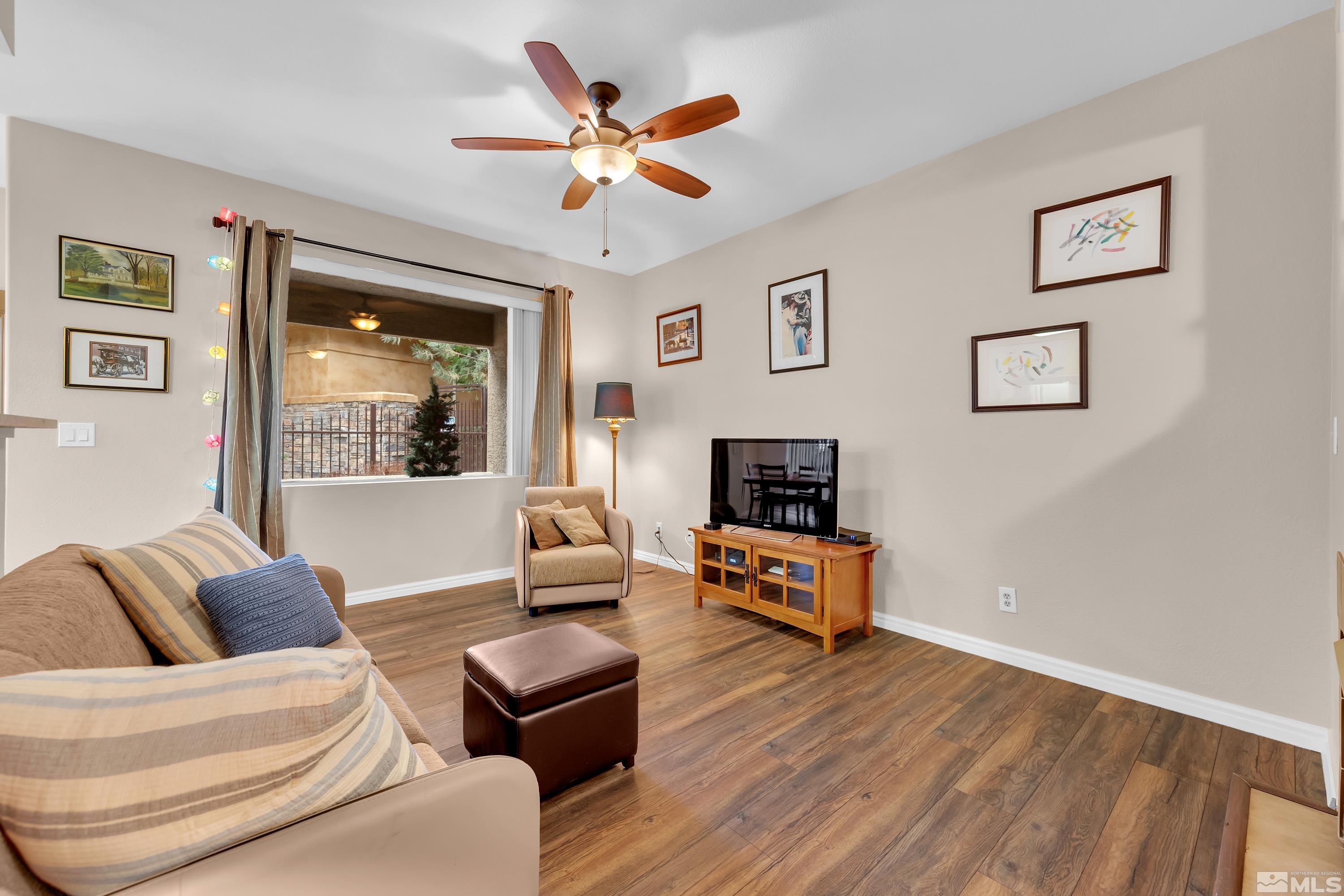 900 South Meadows Parkway, Unit 111 Reno, NV 89521 - Photo 3 of 35 a living room with furniture and a wooden floor