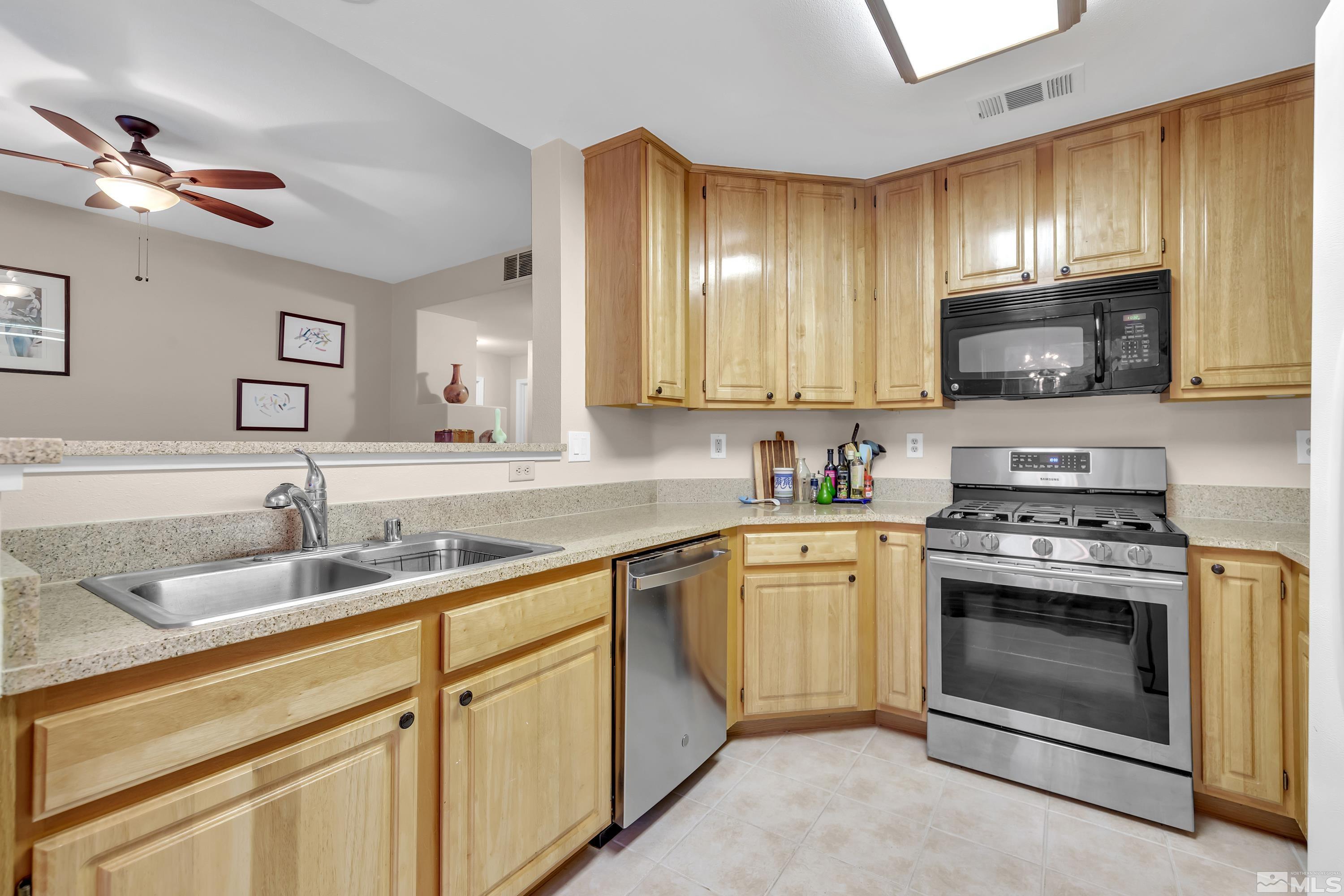 900 South Meadows Parkway, Unit 111 Reno, NV 89521 - Photo 9 of 35 a kitchen with granite countertop a sink stainless steel appliances and cabinets