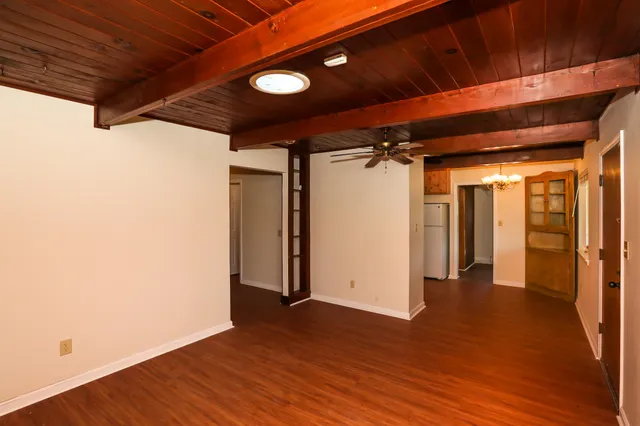 a view of empty room with wooden floor