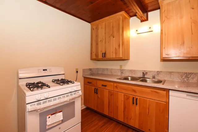 a kitchen with granite countertop cabinets stainless steel appliances and a sink