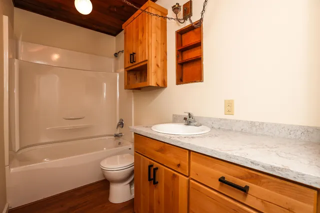 a bathroom with a granite countertop sink toilet and shower