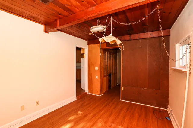 a view of a room with wooden floor and furniture