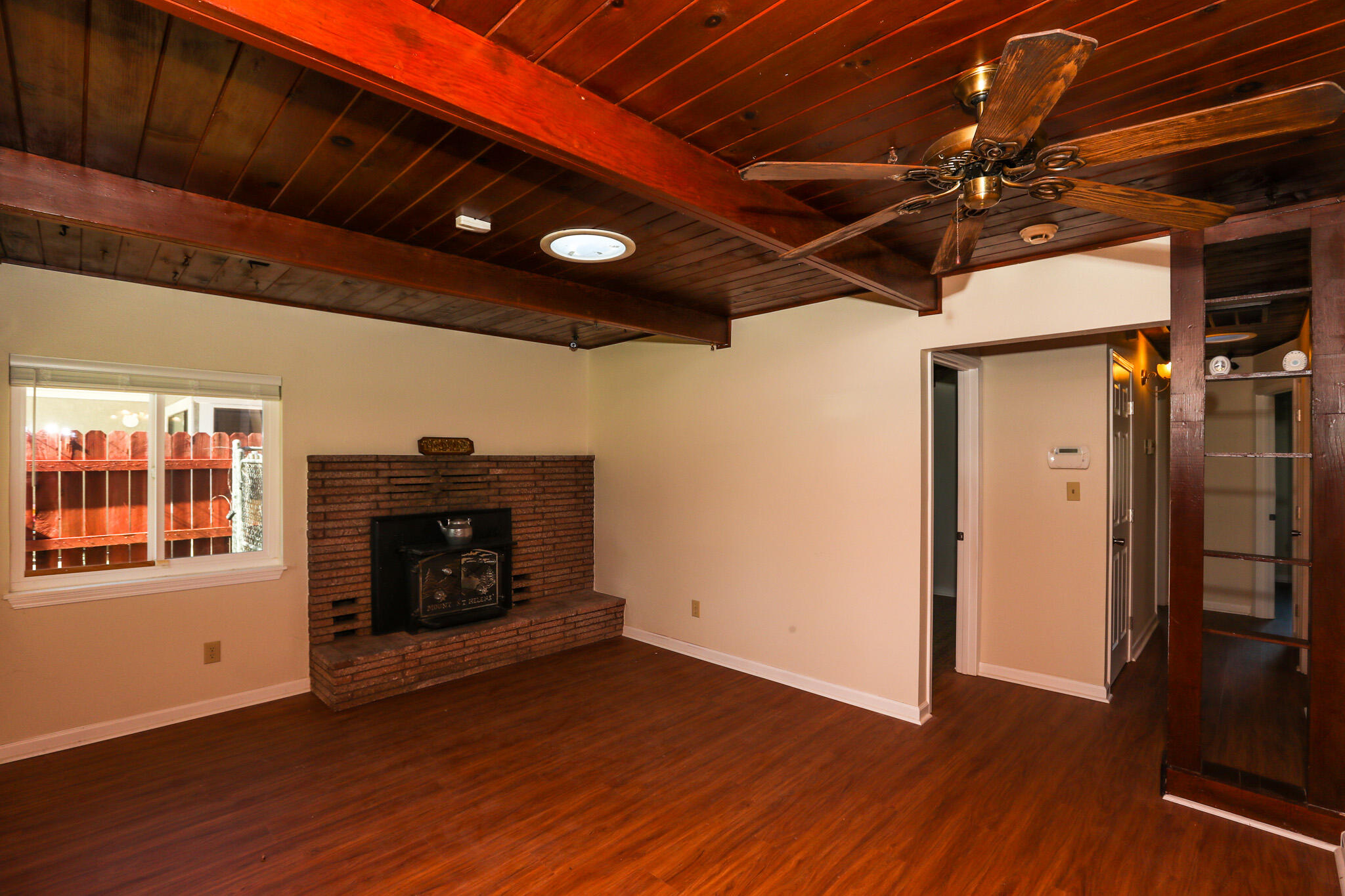 2867 Pinto Lane Anderson, CA 96007 - Photo 8 of 35 a view of an empty room with wooden floor a fireplace and a window