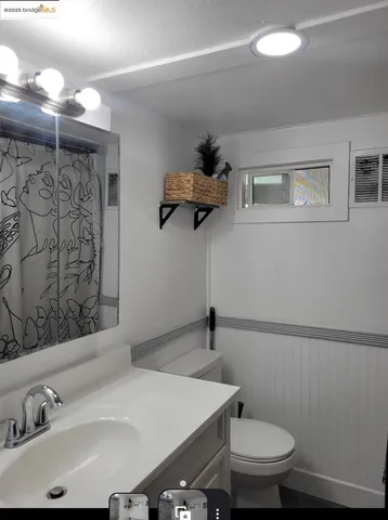a bathroom with a sink a toilet and mirror