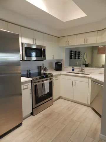 a kitchen with a sink stainless steel appliances and white cabinets