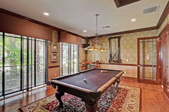 a room with pool table and windows