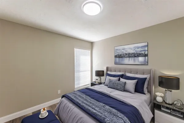 a bedroom with a bed and a painting on the wall