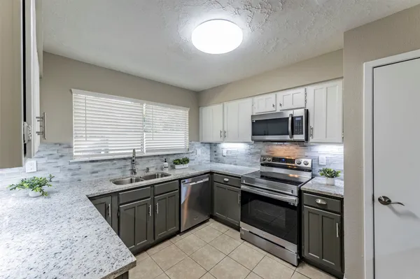 a kitchen with stainless steel appliances granite countertop a sink stove microwave and cabinets